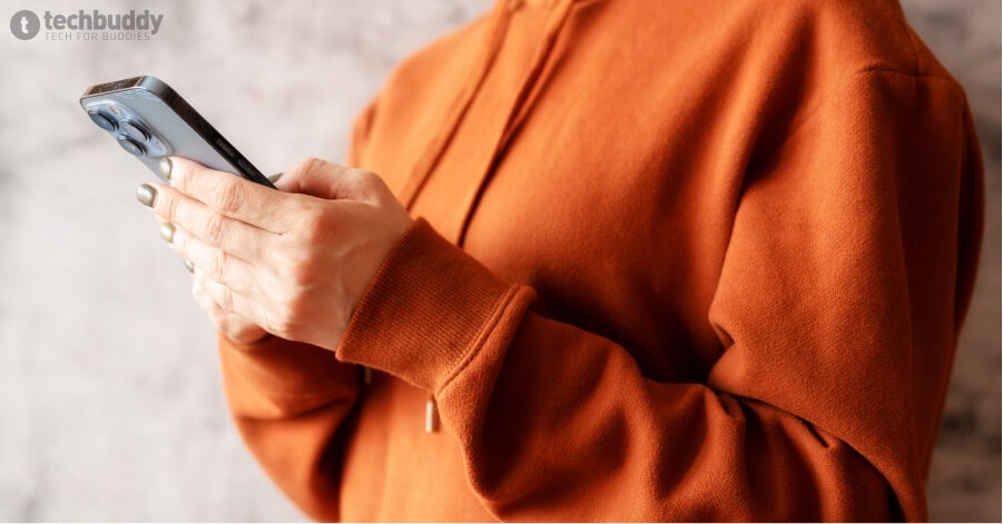 Ilustrasi wanita memegang iPhone di dalam artikel cara menghapus kontak di iPhone