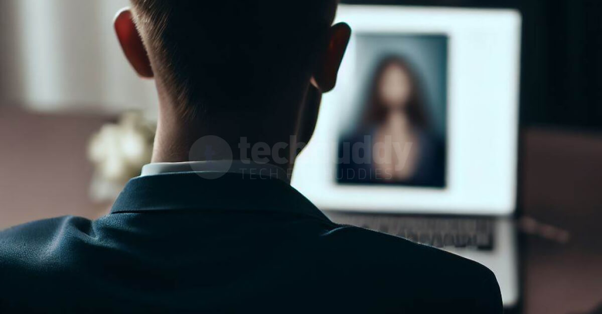 Seorang pria yang terlihat dari belakang sedang menatap laptop berisi foto seorang wanita